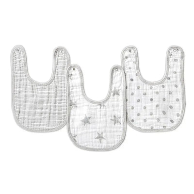 Three Aden + Anais Snap Bibs in dusty tones, featuring patterns of stars and polka dots, designed for baby use.