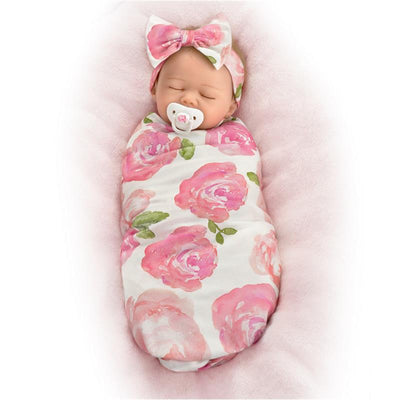 Ashton Drake Rosie Baby Girl Doll swaddled in a floral-patterned blanket with a matching headband and pacifier.