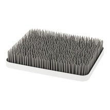 Boon LAWN countertop drying rack in gray and white, featuring numerous upright spikes for drying dishes and utensils.