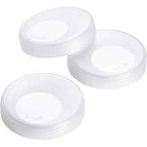 Transparent storage caps from Boon NURSH, three-pack, feature a smooth design with a raised center logo.