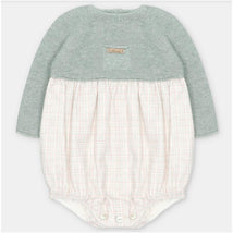 Short romper in sage green sweater knit with a checkered fabric bottom, featuring a small brand tag on the chest.