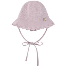 Knit mauve newborn hat with a scalloped edge and tie ribbons, featuring a small decorative embellishment.