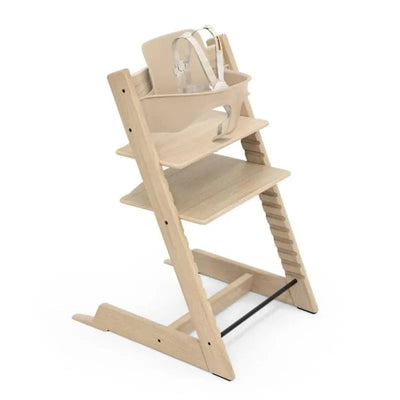 Stokke Tripp Trapp® High Chair in Oak Natural with a beige infant set, designed for safe seating for children.