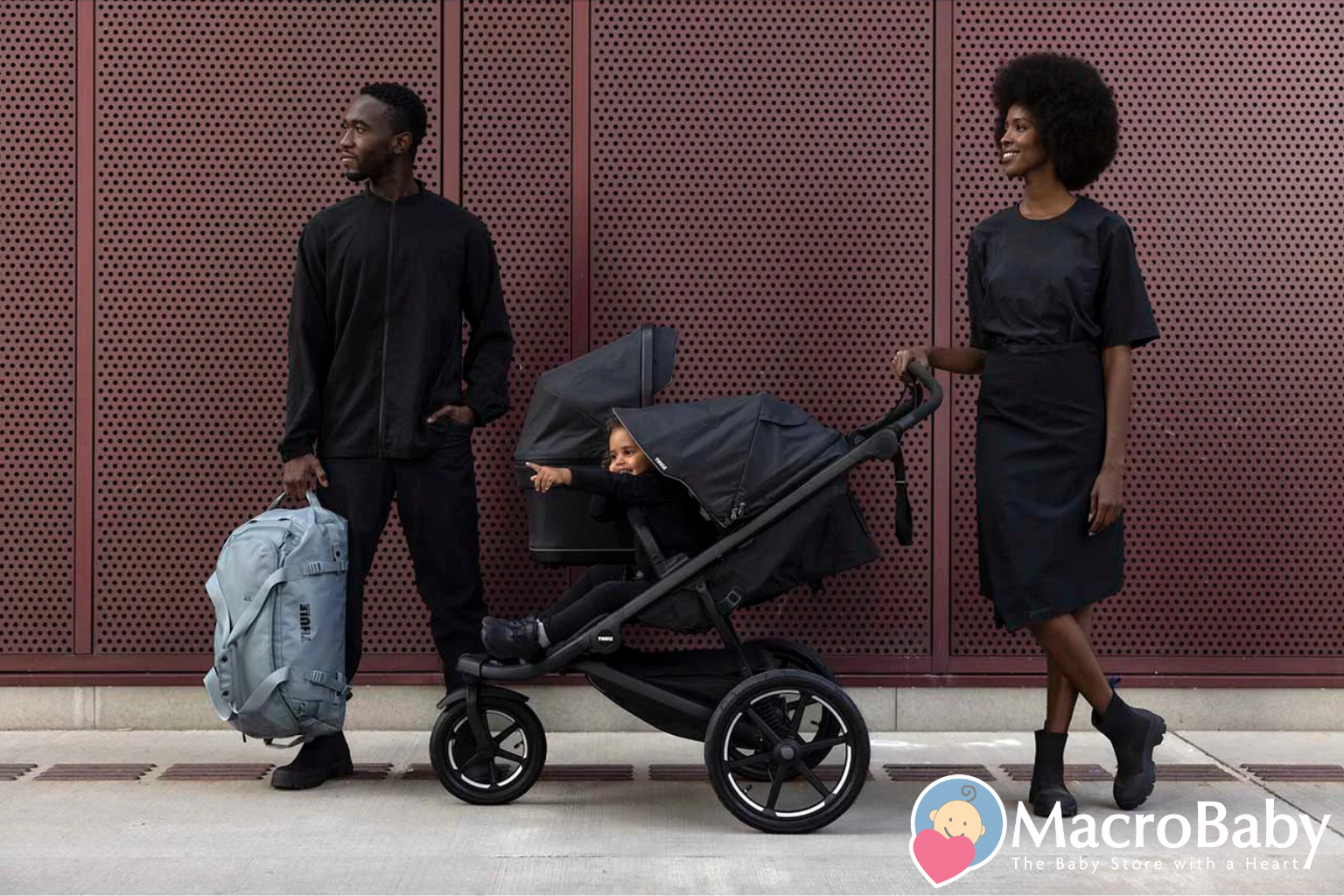 Modern black stroller with baby, parents walking outdoors, urban setting, baby gear essentials
