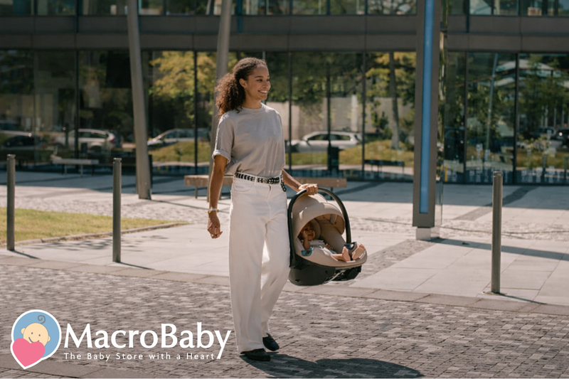 Mom carrying baby in portable car seat stroller outdoors