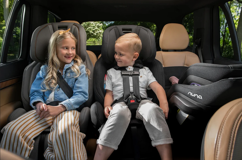 Kids in car seats smiling, safe baby travel gear for families