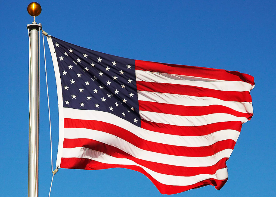 American flag waving against clear blue sky, symbolizing USA pride and freedom