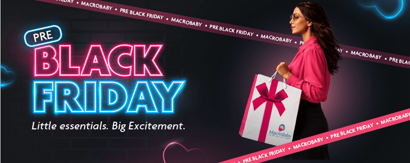 Pre Black Friday at MacroBaby: Little essentials. Big Excitement. Woman carrying a MacroBaby gift bag with a pink bow.