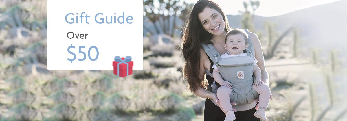 Mom carrying baby in gray ergonomic carrier, desert backdrop, gift guide over $50