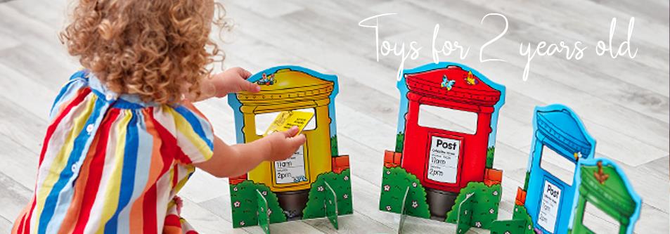 Toddler playing with colorful toy post boxes, perfect for 2-year-olds' imaginative play and learning.