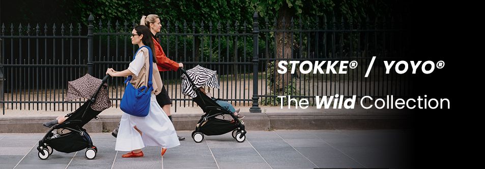 Two moms pushing Stokke YOYO strollers from The Wild Collection on a city sidewalk
