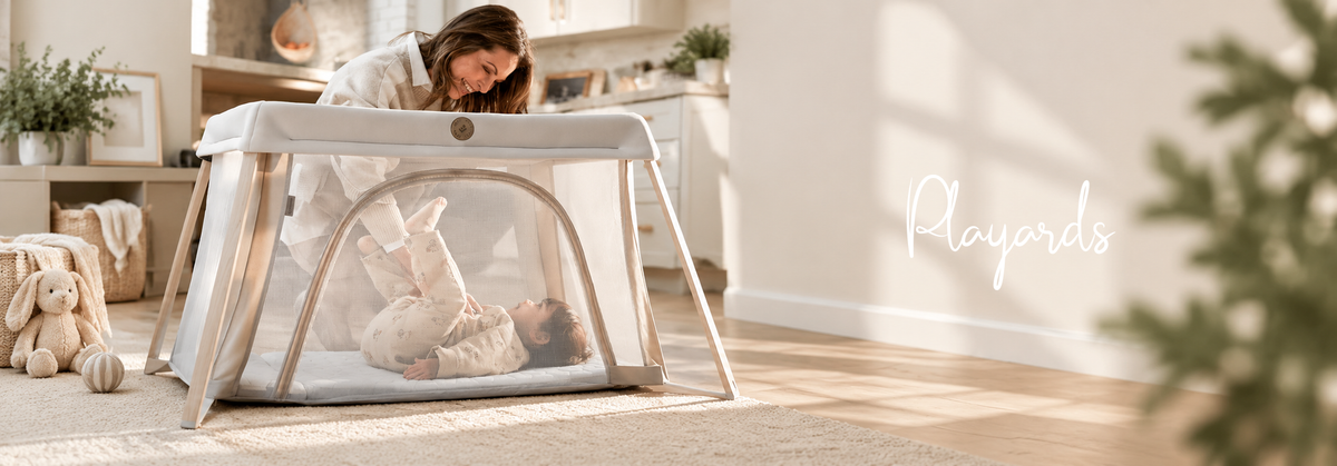 Mother interacting with her baby in a modern mesh playard in a bright, cozy nursery