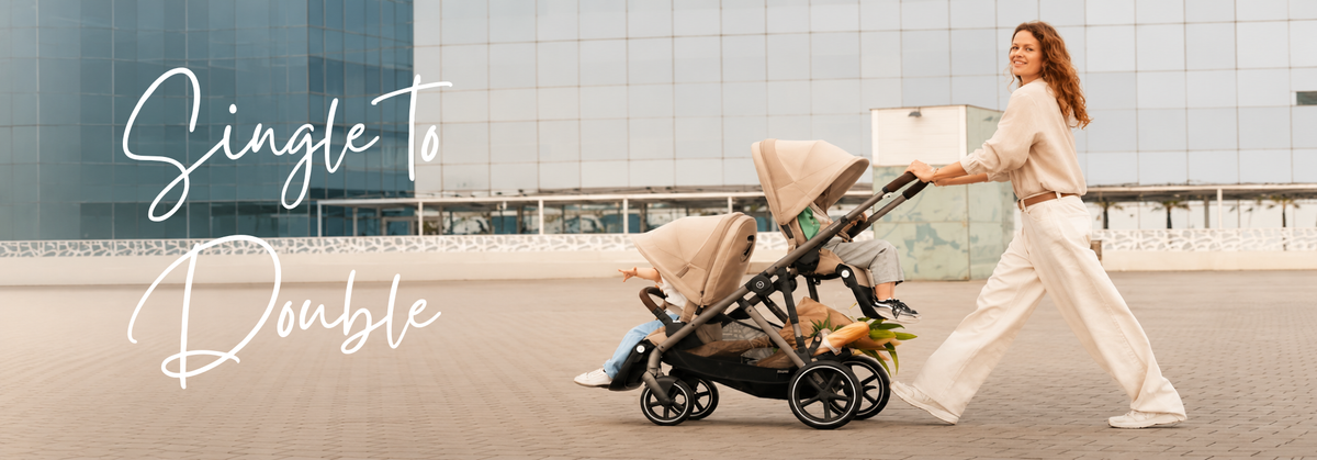 Woman pushing a single to double convertible stroller with two children in a modern urban setting