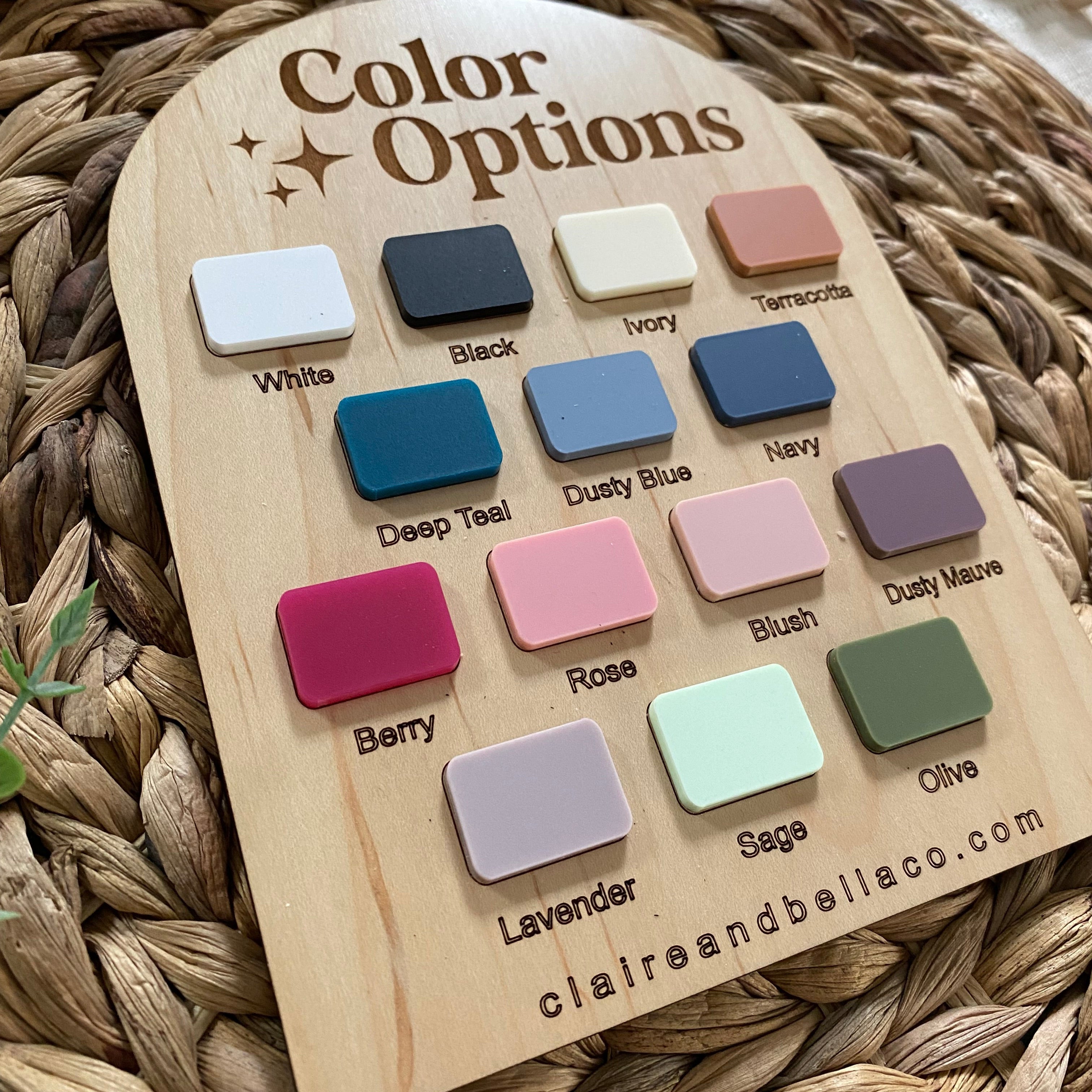 Wooden color swatch board with 14 labeled paint samples for baby products, including White, Black, Rose, Sage, and Olive.