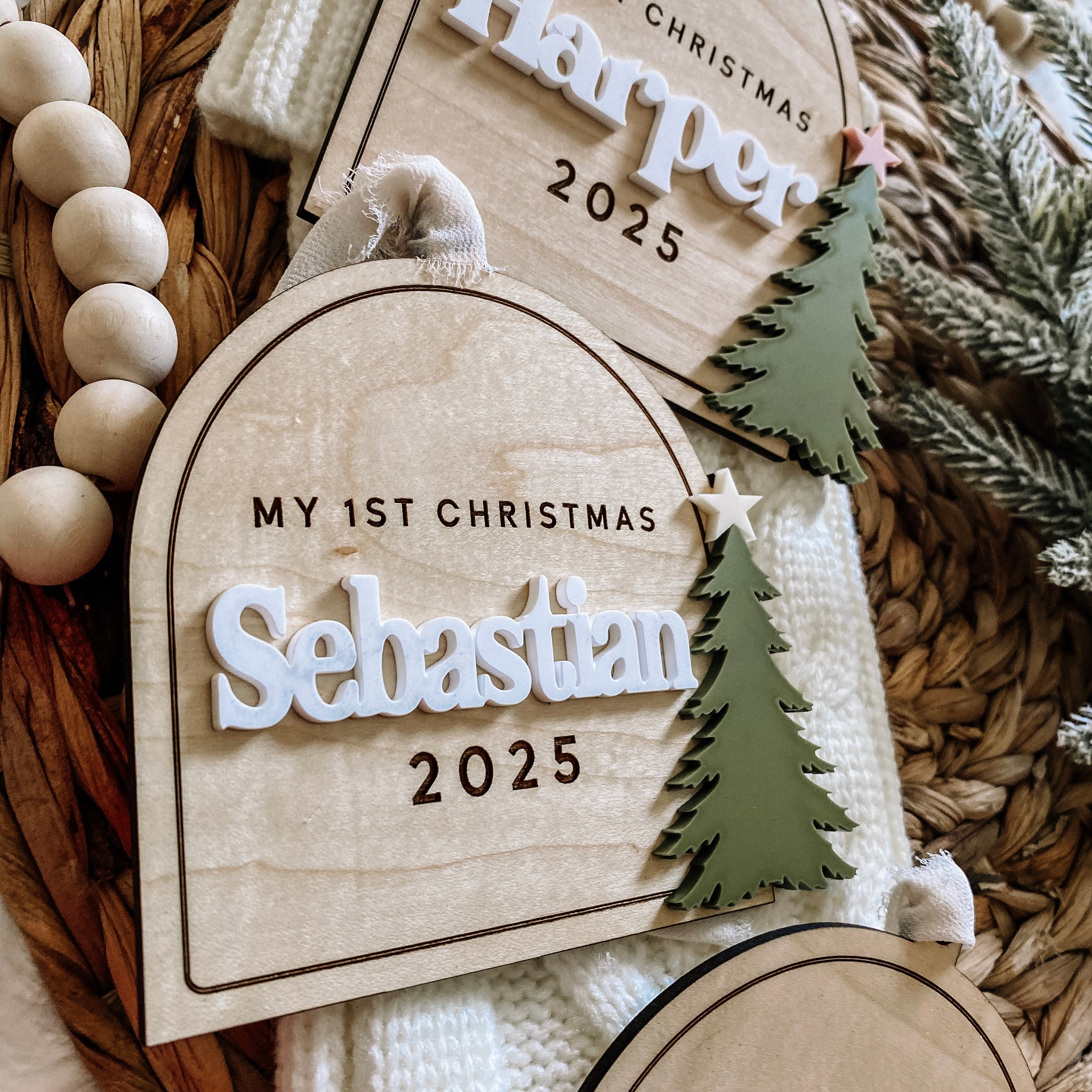Personalized 'My 1st Christmas' baby ornament with name Sebastian 2025, green tree, star, on woven basket