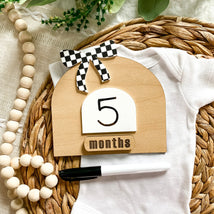 Wooden 5 months baby milestone sign with checkered bow, on white onesie, wicker basket, beads