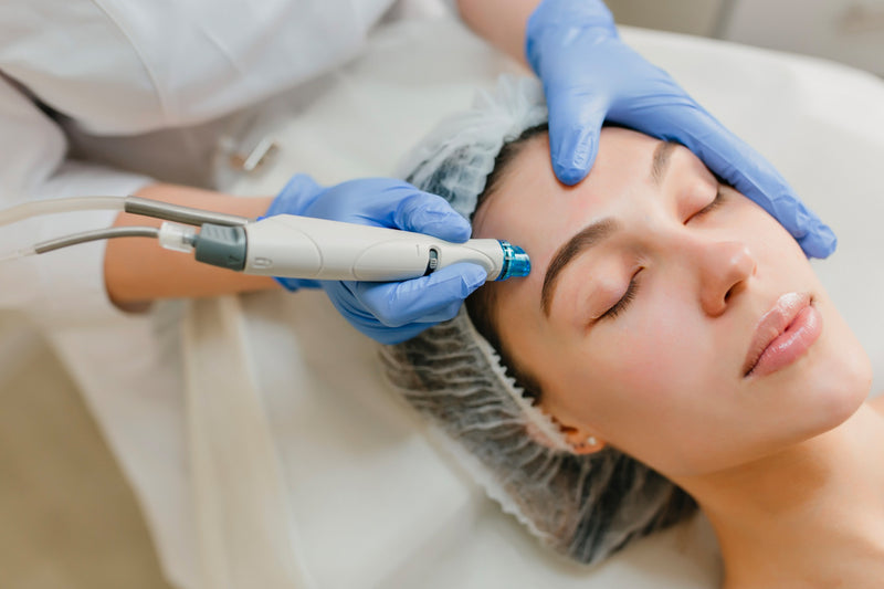 Esthetician conducting a deep exfoliating microdermabrasion on a woman's face
