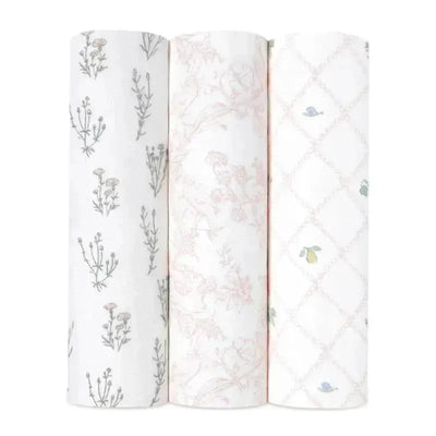 Three Aden + Anais swaddles in varying floral and patterned designs, showcasing soft and breathable fabric suitable for infants.