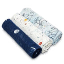 Three Aden + Anais swaddles in soft fabric featuring celestial designs, including stars and animals, rolled neatly.