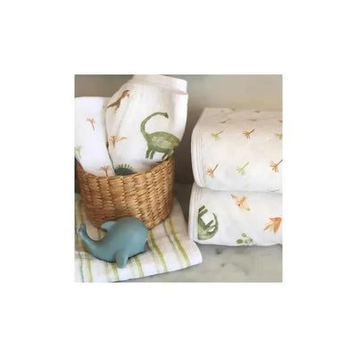 Aden + Anais 3-pack washcloth set featuring dinosaur and jungle designs, with a woven basket and a blue whale toy.