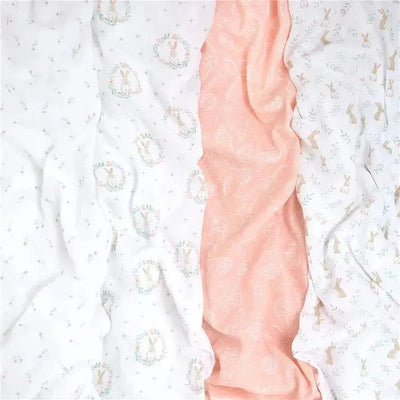 Four muslin swaddles featuring a mix of bunny patterns in pastel colors, including white and peach.