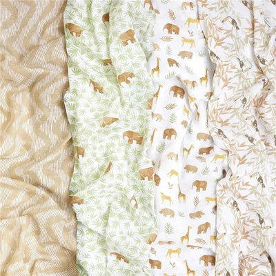 Four muslin swaddles from Aden + Anais featuring animal and nature patterns in earthy colors.