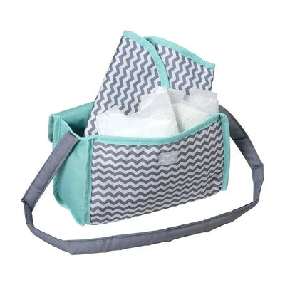 Zig zag print baby doll diaper bag with changing mat and two doll diapers visible inside.