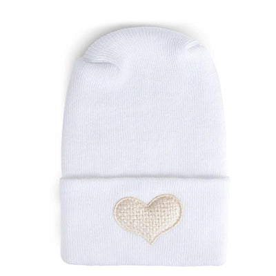 Fuzzy ivory hospital hat for babies with a heart-shaped embroidery on the cuff. Perfect for newborn gifting.