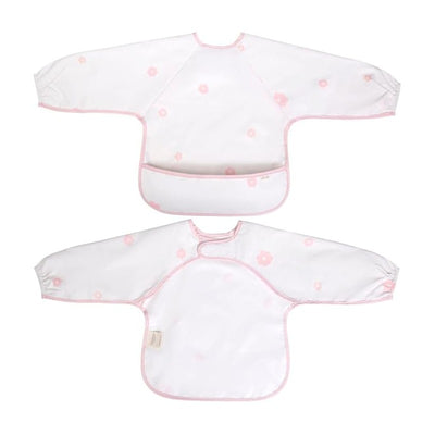Long sleeve smock bib in pink with white background and flower patterns, featuring a pocket for catching spills.