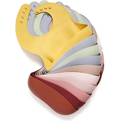 Silicone baby bibs in various soft colors arranged in a fan shape, showcasing their flexible and easy-to-clean design.