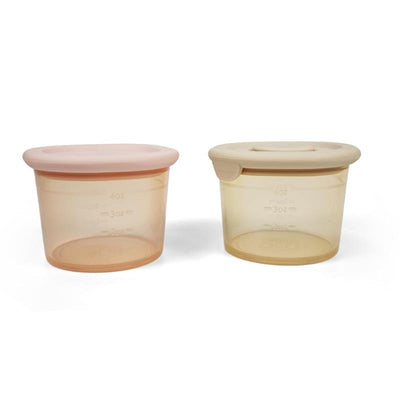 Silicone food containers in blush and khaki, 4oz each, featuring measuring markers on the side.