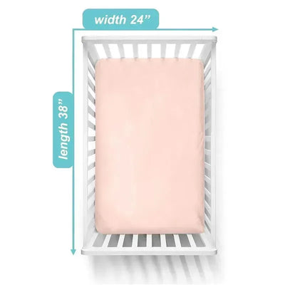 Fitted mini crib sheet in blush color, measuring 24 x 38 inches, made of 100% cotton jersey, placed in a white crib.