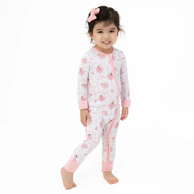 Convertible romper for baby girls featuring a playful pink ballerina print, modeled by a smiling girl with a hair bow.