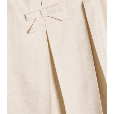 Beige jacquard dress for baby girls featuring a bow detail and pleated design. Ideal for formal occasions.