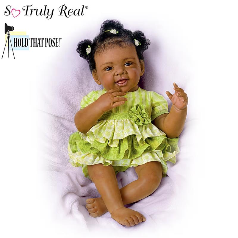 Alexis Baby Doll by Ashton Drake, featuring a smiling baby doll in a green dress with a flower detail.