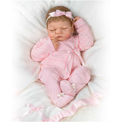 Ashton Drake Emily Baby Girl Doll, 20th Anniversary edition, dressed in a pink outfit with a matching headband, sleeping.