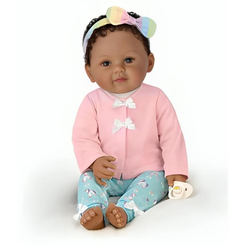 Ashton Drake Ciara Baby Doll with curly hair, wearing a pink top and patterned pants, holding a pacifier.