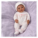 Lifelike Ashton Drake Tiny Miracles 10 Little Kiara doll, dressed in a pink heart-patterned onesie and matching hat, on a soft purple blanket.