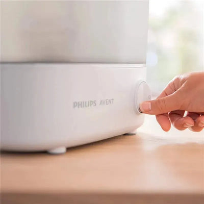 Avent Advanced Electric Steam Sterilizer with a hand pressing the power button, showcasing its sleek design.