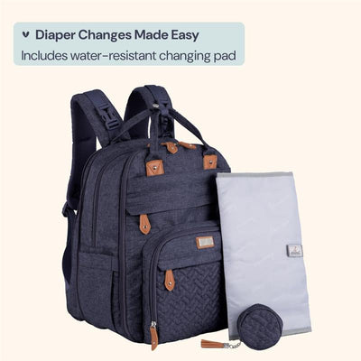 Denim blue travel essentials baby bag tote with changing pad, featuring brown accents and multiple compartments.