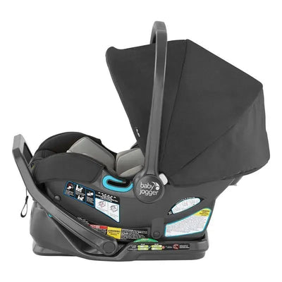 Baby Jogger City Go 2 Vbl Car Seat in slate color, featuring a handle, canopy, and visible safety instructions on the base.