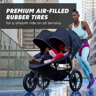 Double jogging stroller with air-filled rubber tires; woman jogging with two children onboard in urban setting.