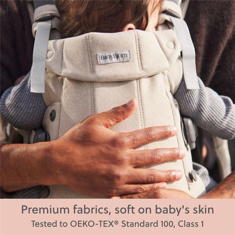 BabyBjörn Baby Carrier Harmony in Light Beige, featuring premium soft fabrics, shown with a child safely nestled.