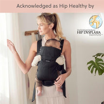 Babybjorn Baby Carrier Mini in black, featuring a mother holding a baby, stylish and ergonomic 3D mesh design, acknowledged as hip healthy.