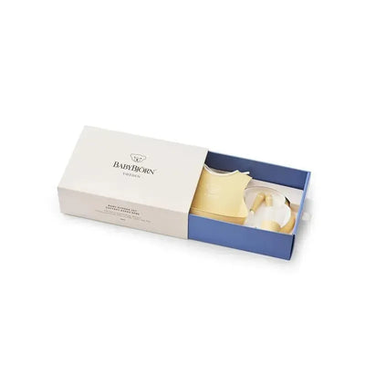 A BabyBjorn 5-piece baby dinner set in powder blue, featuring a plate, bowl, cup, and utensils displayed in a box.