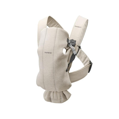 Light beige Babybjorn Carrier Mini made of 3D jersey fabric, featuring adjustable straps and a snug design for infants.