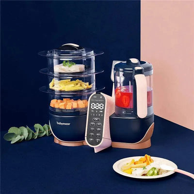 Babymoov Duo Meal Station XL 6-in-1 food processor, featuring a steamer, blender, and a plated meal of vegetables and rice.