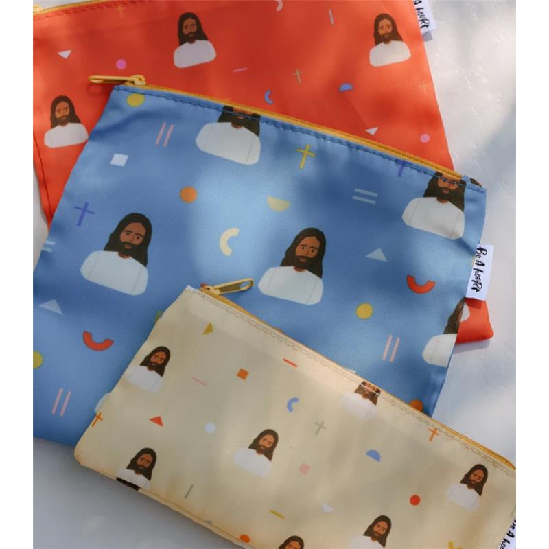 Three reusable snack bags featuring colorful designs of Jesus, with patterns including religious symbols and abstract shapes.