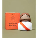 Jesus silicone night light with a smiling face and orange sash, next to its orange packaging, on a neutral background.