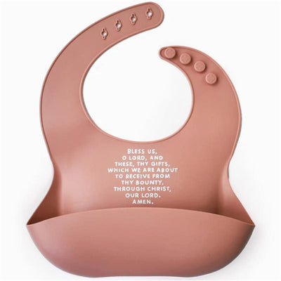 Rose pink silicone bib featuring the text, “Bless us, O Lord, and these, thy gifts...” designed for children.